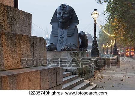 Stock Photograph - Sphinx at the foot of Cleopatra's Needle on the Embankment, with Big Ben in the distance; London, England. Fotosearch