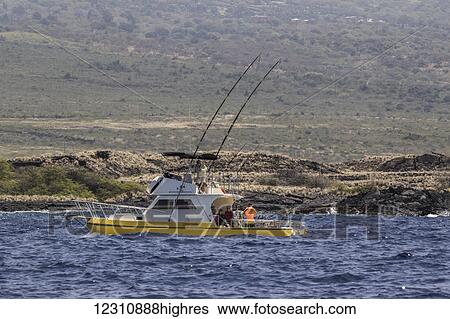Stock Photograph - Sportfishing boat with deployed fishing rods trolling off the Kona coast; Kona, Island of Hawaii, Hawaii, United States of America. Fotosearch