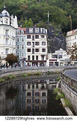 Stock Photograph - Statue of Christ on the cross above town and river; Karlova Vary, Czech Republic. Fotosearch