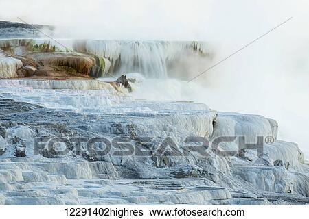 Stock Photograph - Steam covers formations at Mammoth Springs in Yellowstone National Park; Wyoming, United States of America. Fotosearch