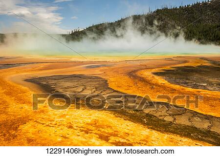 Stock Photograph - Steam rises from the Grand Prismatic Spring in Yellowstone National Park; Wyoming, United States of America. Fotosearch