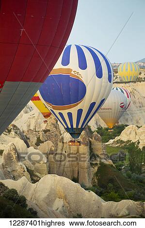 Stock Photograph - Sunrise balloon ride over Goreme National Park, passing over fairy chimneys; Cappadocia, Turkey. Fotosearch
