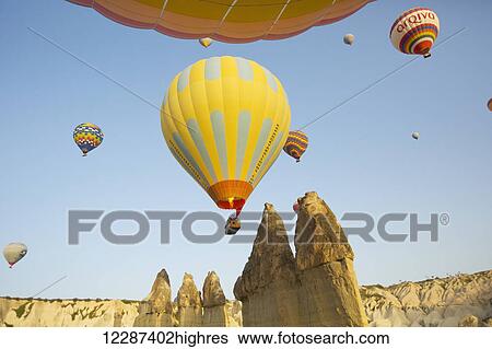 Stock Photograph - Sunrise balloon ride over Goreme National Park, passing over fairy chimneys; Cappadocia, Turkey. Fotosearch