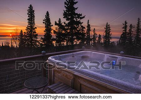 Stock Photograph - Sunset view from a deck and hot tub on the Anchorage hillside, South-central Alaska. Fotosearch