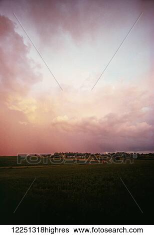 Stock Photograph - Sunset with clouds above an alfalfa field in the midwestern United States; United States of America. Fotosearch