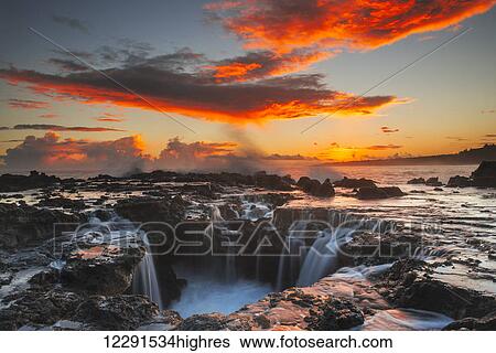 Surf spills into a hole in a rock outcrop at sunrise on the east side of Kauai; Kauai, Hawaii, United States of America View Large Photo Image Stock Photograph - Surf spills into a hole in a rock outcrop at sunrise on the east side of Kauai; Kauai, Hawaii, United States of America. Fotosearch
