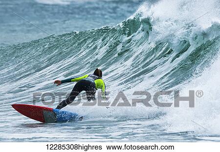 Stock Photograph - Surfer catching a wave; Tarifa, Cadiz, Andalusia, Spain. Fotosearch