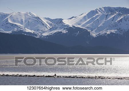 Surfers ride a large bore tide in Turnagain Arm in Summer. Southcentral Alaska. Mile 94 Seward Highway. View Large Photo Image Stock Photograph - Surfers ride a large bore tide in Turnagain Arm in Summer. Southcentral Alaska. Mile 94 Seward Highway.. Fotosearch