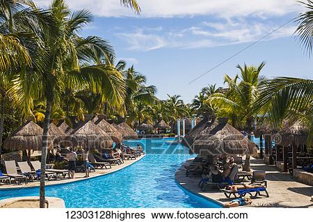 Stock Photograph - Swimming pool and tourists sunbathing at a resort on the Caribbean; Playa del Carmen, Quintana Roo, Mexico. Fotosearch