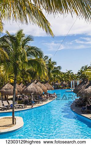 Swimming pool and tourists sunbathing at a resort on the Caribbean; Playa del Carmen, Quintana Roo, Mexico View Large Photo Image Stock Photograph - Swimming pool and tourists sunbathing at a resort on the Caribbean; Playa del Carmen, Quintana Roo, Mexico. Fotosearch