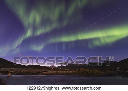 The aurora borealis dances in the sky over the Dietrich River and the Trans Alaska Pipeline in the Brooks Range north of Wiseman, Alaska. View Large Photo Image Stock Photograph - The aurora borealis dances in the sky over the Dietrich River and the Trans Alaska Pipeline in the Brooks Range north of Wiseman, Alaska.. Fotosearch