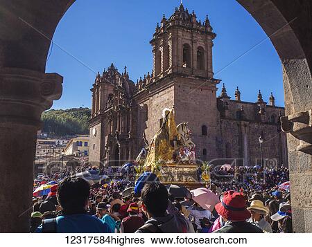 Stock Photograph - The Corpus Christi religious festival takes place in the Plaza de Armas with the Cathedral de Cusco in the background, 60 days after Easter; Cusco, Peru. Fotosearch