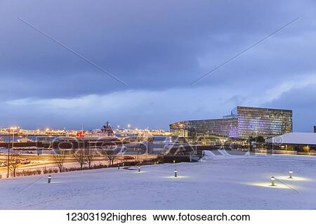 Stock Photograph - The Harpa Public Concert Hall as seen from Arnarholl Park, designed by Danish firm Henning Larsen Architects and Icelandic firm Batteriao Architects, the glass facade was designed by Icelandic glass artist Olafur Eliasson, a snowy field in the.... Fotosearch