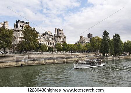 The Hotel de Ville viewed from a bridge with a tour boat passing by; Paris, France View Large Photo Image Stock Photograph - The Hotel de Ville viewed from a bridge with a tour boat passing by; Paris, France. Fotosearch