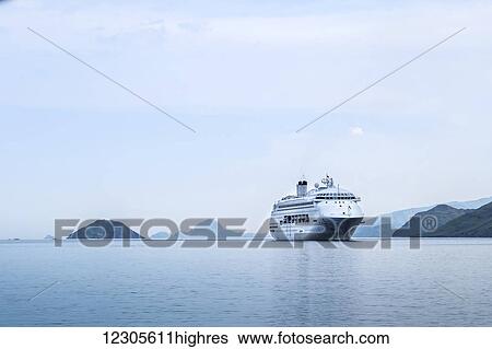 Stock Photograph - The Pacific Jewel off Komodo Island, a cruise ship operated by the P&O cruise line, holding up to 1, 950 guests and has 11 guest decks; Flores, Indonesia. Fotosearch