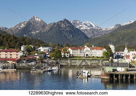 Stock Photograph - The Pier at the Sitka Harbor with downtown Sitka and the Sisters mountains in the background, Southeast Alaska, USA, Summer. Fotosearch