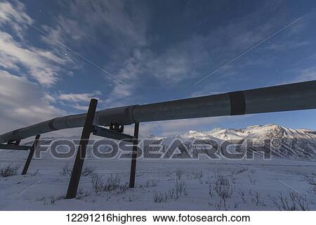 Stock Photograph - The Trans Alaska Pipeline stands out against the sky on the other side of Atigun Pass in the Brooks Range, Arctic Alaska. Fotosearch