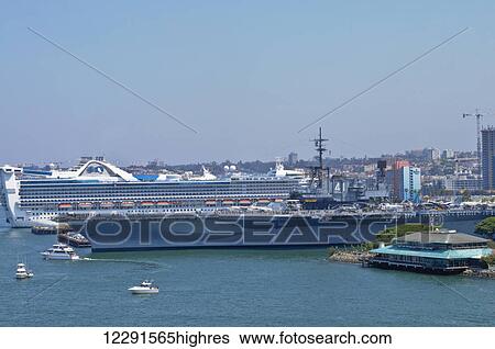 Stock Photograph - The USS Midway (CV-41) rests at port in San Diego alongside a Princess Cruise vessel; San Diego, California, United States of America. Fotosearch