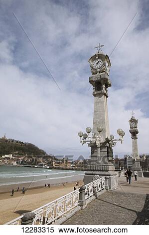 Stock Photography - The wide sands of La Concha beach in this popular resort town, European Capital of Culture in 2016, the two pillars house a clock and a barometer; San Sebastian, Spain. Fotosearch