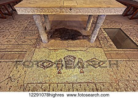 Stock Photograph - This altar is built over the rock where it is said that Jesus took the two fish and five loaves of bread and blessed them; Tabgha, Israel. Fotosearch