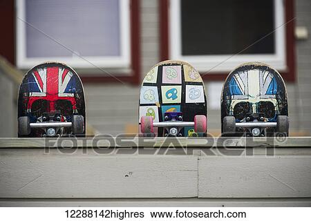 Stock Photograph - Three skateboards resting against a wooden wall; Spitsbergen, Svalbard, Norway. Fotosearch