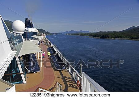 Stock Photograph - Top deck of Celebrity cruise ship as it cruises north on channel out of Ketchikan, Southeast Alaska, summer. Fotosearch