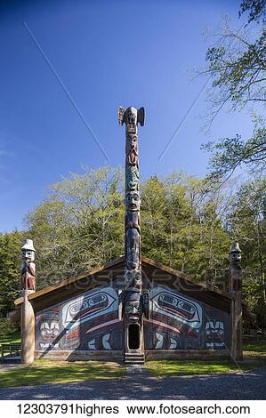 Stock Photograph - Totem poles outside a large clan house painted with images of the raven, Totem Bight Historic State Park, Ketchikan, Southeast Alaska, USA, Spring. Fotosearch