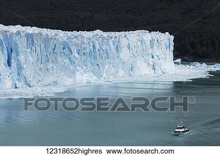 Stock Photograph - Tour boat in front of Perito More0 Glacier in Los Glaciares National Park, Argentinian Patagonia; Santa Cruz Province, Argentina. Fotosearch