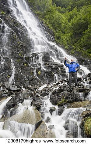 Stock Photograph - Tourist taking a selfie at Bridalveil Falls, Keystone Canyon, Valdez, Southcentral Alaska, USA. Fotosearch