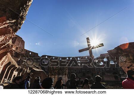 Stock Photograph - Tourists and a cross in the Colosseum; Rome, Italy. Fotosearch