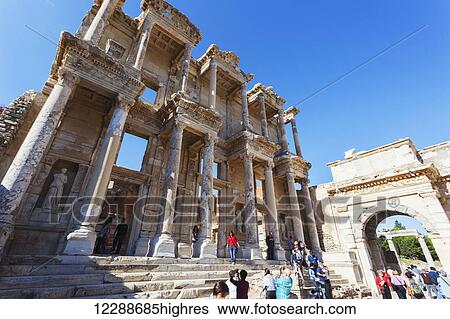 Stock Photograph - Tourists at the ruins of the Celsus Library, a monumental tomb for Gaius Julius Celsus Polemaeanus; Ephesus, Izmir, Turkey. Fotosearch