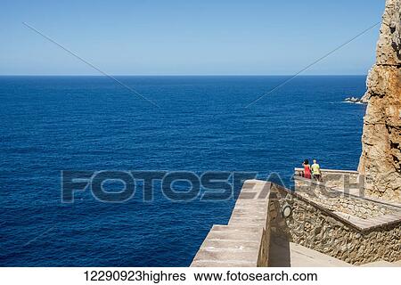 Stock Photograph - Tourists descending to Neptune's Grotto in Capo Caccia; Alghero, Sardinia, Italy. Fotosearch