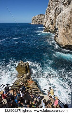Stock Photograph - Tourists descending to Neptune's Grotto in Capo Caccia; Alghero, Sardinia, Italy. Fotosearch