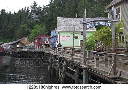 Stock Photograph - Tourists enjoy a visit to the boardwalk on Creek Street, Ketchikan, Southeast Alaska, summer. Fotosearch