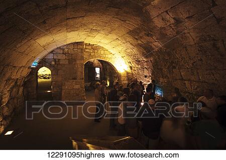 Stock Photograph - Tourists gather underground to view historic displays; Jerusalem, Israel. Fotosearch