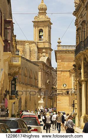 Stock Photograph - Tourists walking toward St. Paul's Cathedral; Mdina, Malta. Fotosearch