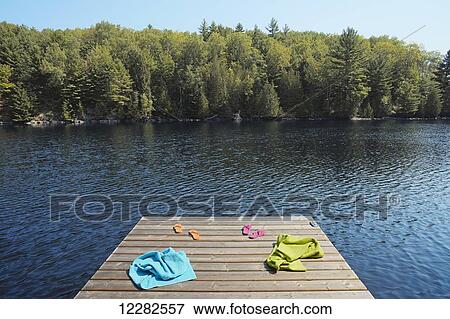 Towels and flip-flops on dock; Crystal Lake, Ontario, Canada View Large Photo Image Stock Photo - Towels and flip-flops on dock; Crystal Lake, Ontario, Canada. Fotosearch