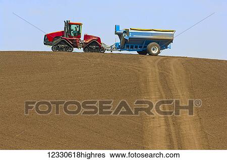 Tractor Pulling A Grain Cart Sits On The Top Of A Hill Against A Blue Sky; Washington, United States Of America View Large Photo Image Stock Photograph - Tractor Pulling A Grain Cart Sits On The Top Of A Hill Against A Blue Sky; Washington, United States Of America. Fotosearch