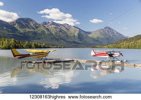 Two float planes docked at the Trail Lake Float Plane Base on a clear day, the Kenai Mountains in the background, Kenai Peninsula, Southcentral Alaska, USA, Summer View Large Photo Image Stock Photograph - Two float planes docked at the Trail Lake Float Plane Base on a clear day, the Kenai Mountains in the background, Kenai Peninsula, Southcentral Alaska, USA, Summer. Fotosearch