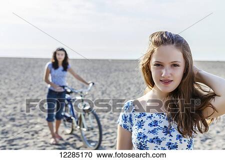 Two girls standing on a beach with bike; Toronto, Ontario, Canada View Large Photo Image Stock Image - Two girls standing on a beach with bike; Toronto, Ontario, Canada. Fotosearch