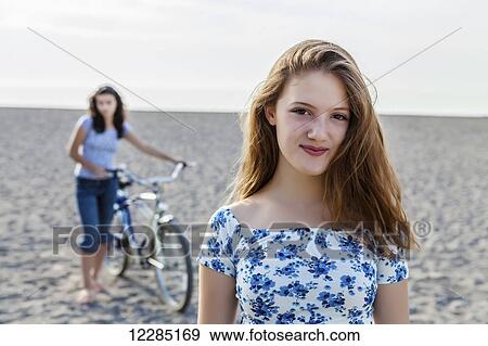 Two girls standing on a beach with bike; Toronto, Ontario, Canada View Large Photo Image Stock Photo - Two girls standing on a beach with bike; Toronto, Ontario, Canada. Fotosearch