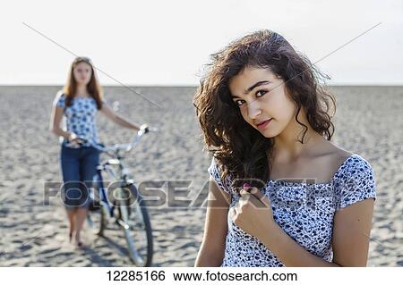 Two girls standing on a beach with bike; Toronto, Ontario, Canada View Large Photo Image Stock Photograph - Two girls standing on a beach with bike; Toronto, Ontario, Canada. Fotosearch