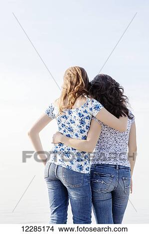 Picture - Two girls with their arms around each other; Toronto, Ontario, Canada. Fotosearch