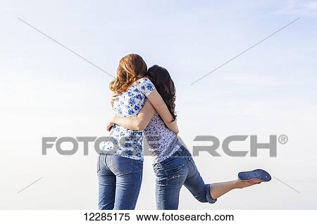 Two girls with their arms around each other; Toronto, Ontario, Canada View Large Photo Image Stock Photography - Two girls with their arms around each other; Toronto, Ontario, Canada. Fotosearch