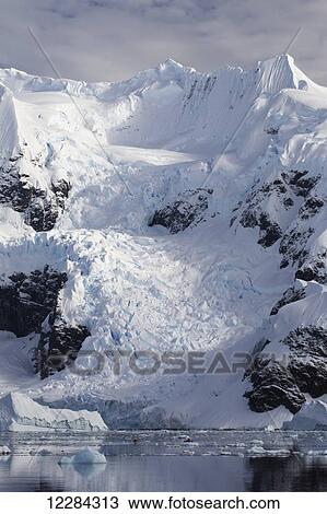 Stock Image - Two kayakers in Paradise Harbor, Antarctic Peninsula; Antarctica. Fotosearch