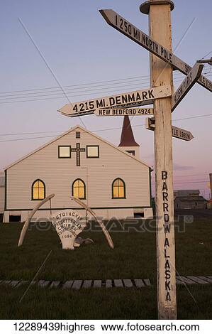 Stock Photograph - Utgiagvik Presbeterian church and direction sign at sunset, Barrow, North Slope, Arctic Alaska, Summer. Fotosearch