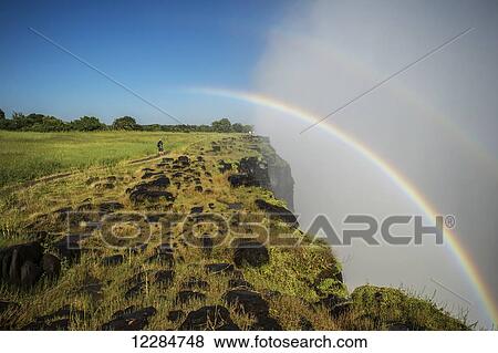 Victoria Falls waterfall with rainbow; Victoria Falls, Zimbabwe View Large Photo Image Stock Photo - Victoria Falls waterfall with rainbow; Victoria Falls, Zimbabwe. Fotosearch