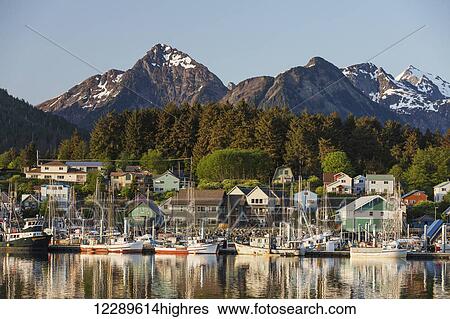 Stock Photograph - View of boats in Sitka Harbor and homes and the Sisters Mountains in the background, Sitka, Southeast Alaska, summer. Fotosearch