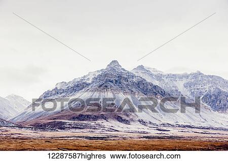 Stock Photograph - View of fresh snow on Soakpak Mountain as seen from the village of Anaktuvuk Pass, Brooks Range, Arctic Alaska, USA, Winter. Fotosearch