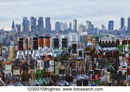 Stock Photograph - View of Levent business district in Istanbul from a rooftop bar with bottles mirroring the effect of the skyscrapers; Istanbul, Turkey. Fotosearch